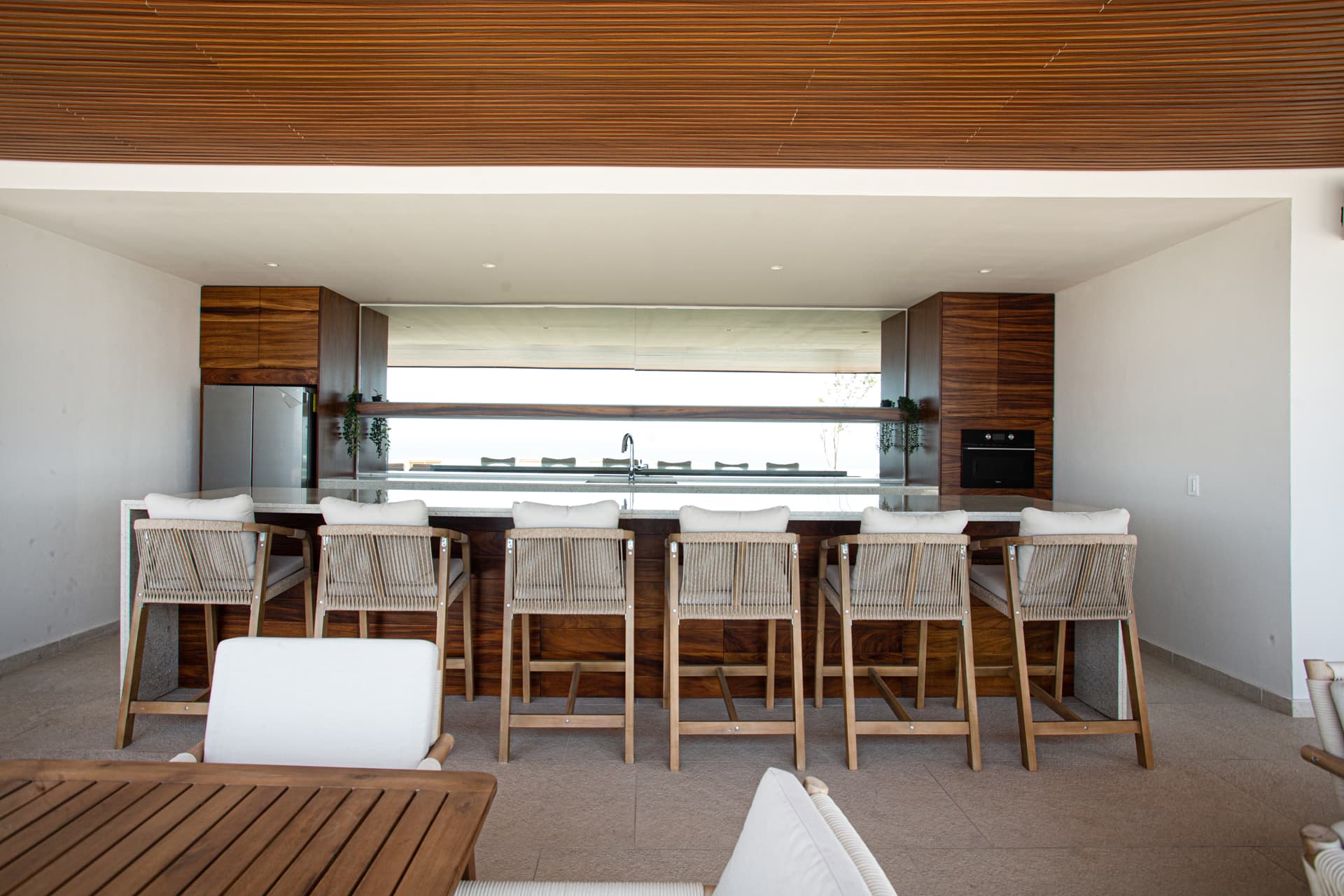 The rooftop showcases a refined bar and oven as part of its elevated entertainment amenities, enhancing the atmosphere for professionally hosted experiences and private events.