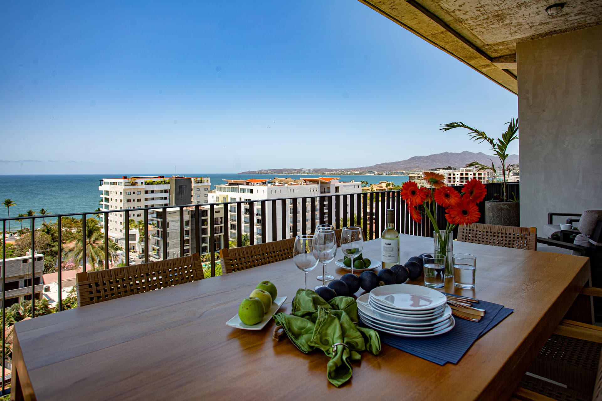 The large wraparound balcony is a standout feature with stunning ocean and mountain views and dining seating for 8.  To the right of the table is a cozy seating area perfect for morning coffee just off the primary bedroom or taking in the sunset.