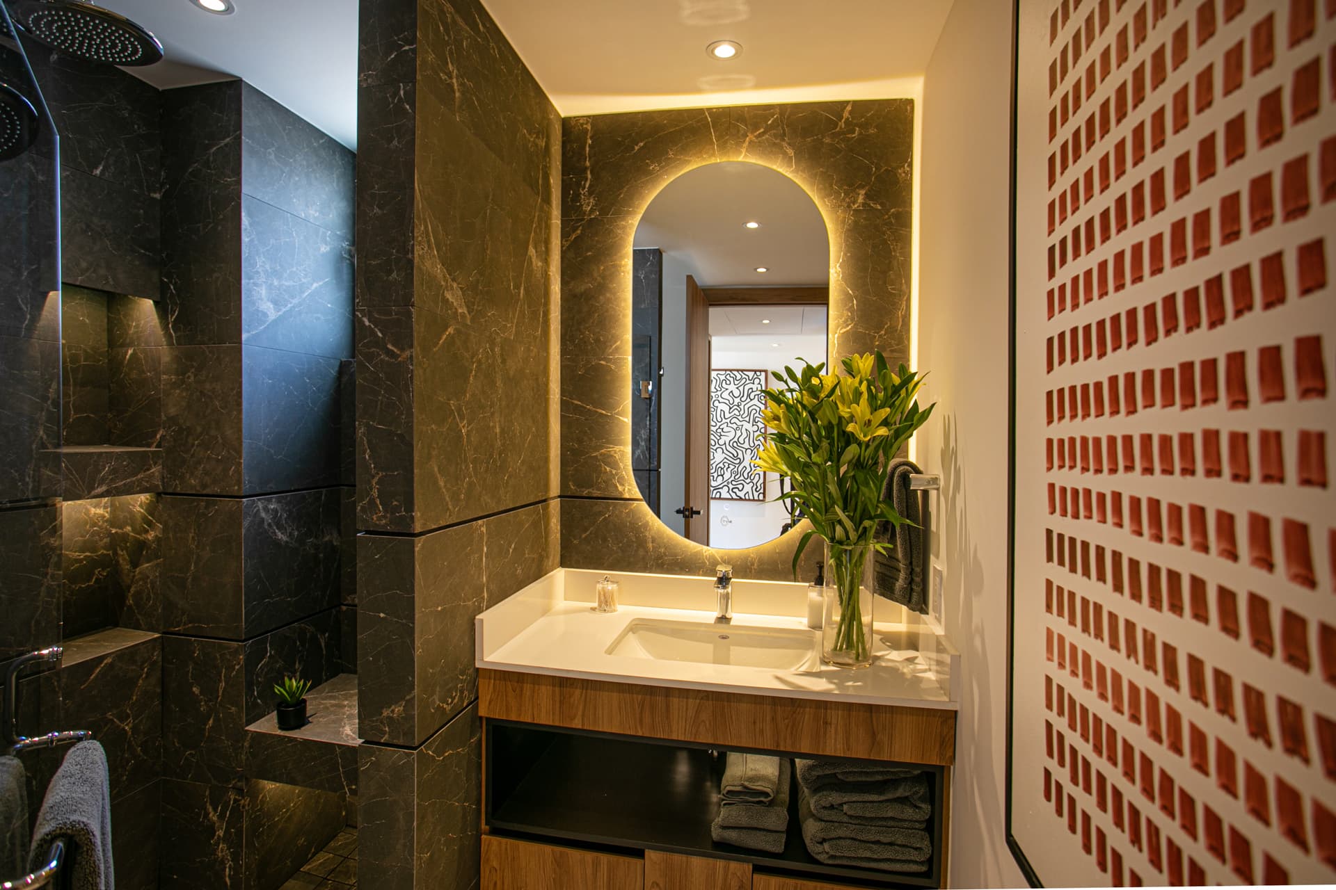 Full-size bathroom featuring a rainshower, wall shower, hand wand, and a bench for added comfort.