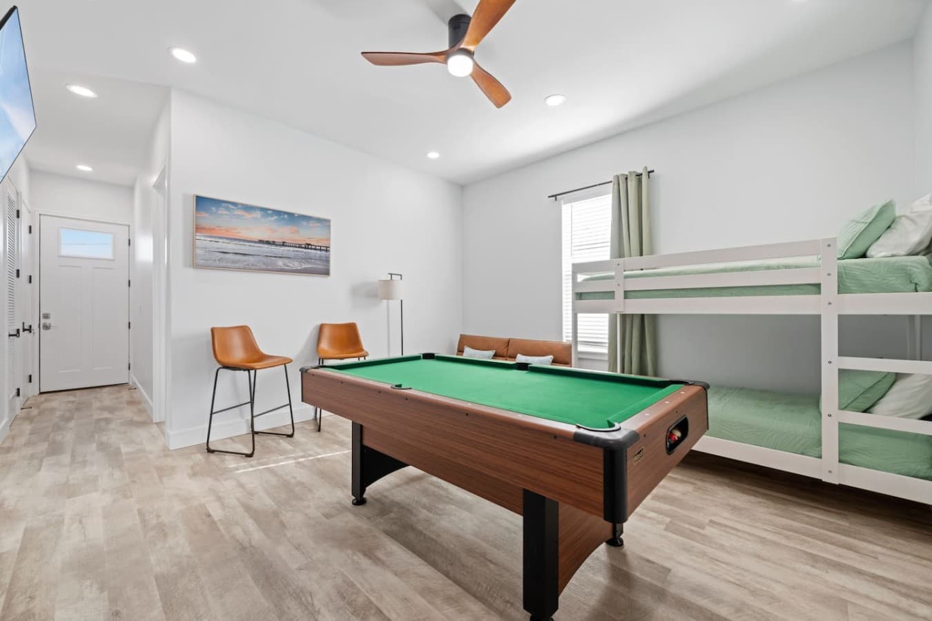 A second living space is upstairs in the home, which features additional bedding, a pool table and a large smart TV