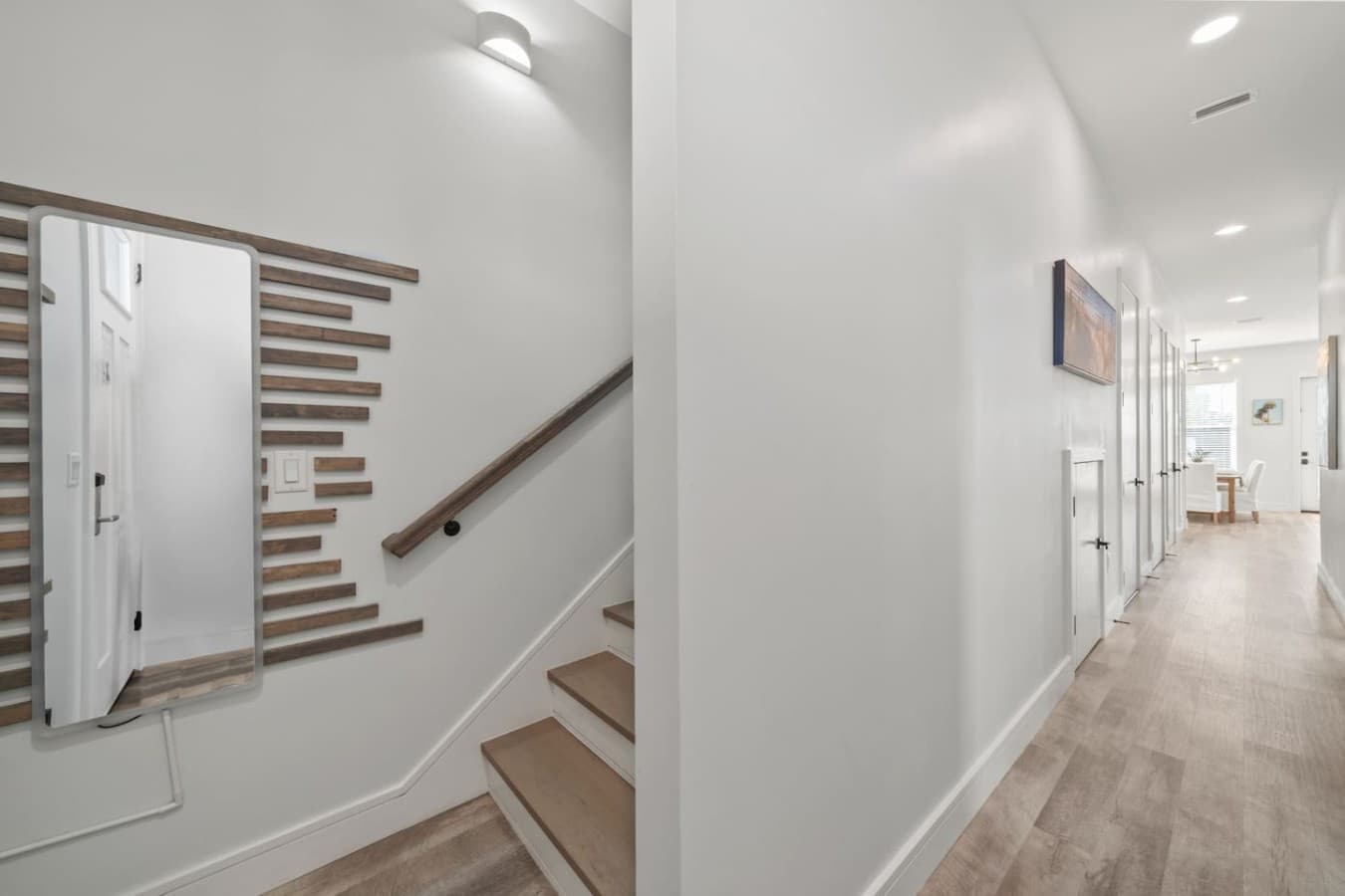 Entryway with stairs to the upstairs on the left and two bedrooms, kitchen and living room straight ahead