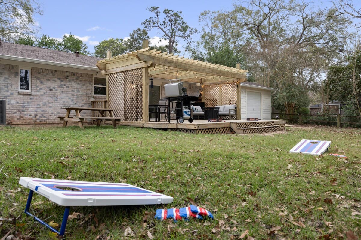 An open yard sets the stage for lawn games, with the pergola-covered deck just steps away for relaxing, dining, or grilling.
