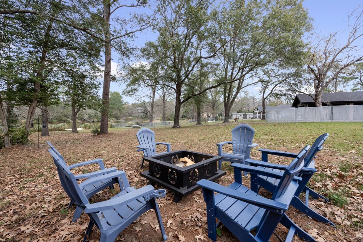 Relaxing fire pit gathering area set beneath mature trees, creating a peaceful spot to unwind and enjoy the open outdoor setting.