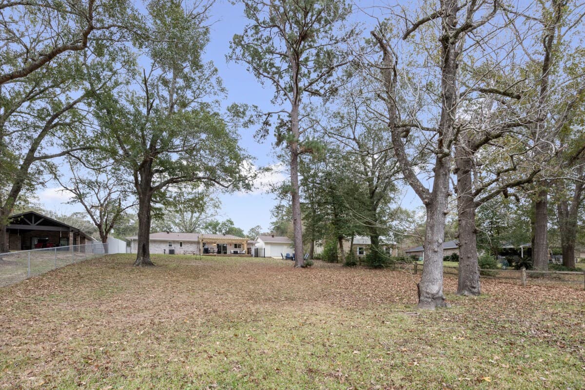 Spacious, tree-lined backyard with room to relax, play, or gather as the day winds down. Picture quiet afternoons under the shade and evenings filled with fresh air, open space, and peaceful surroundings.