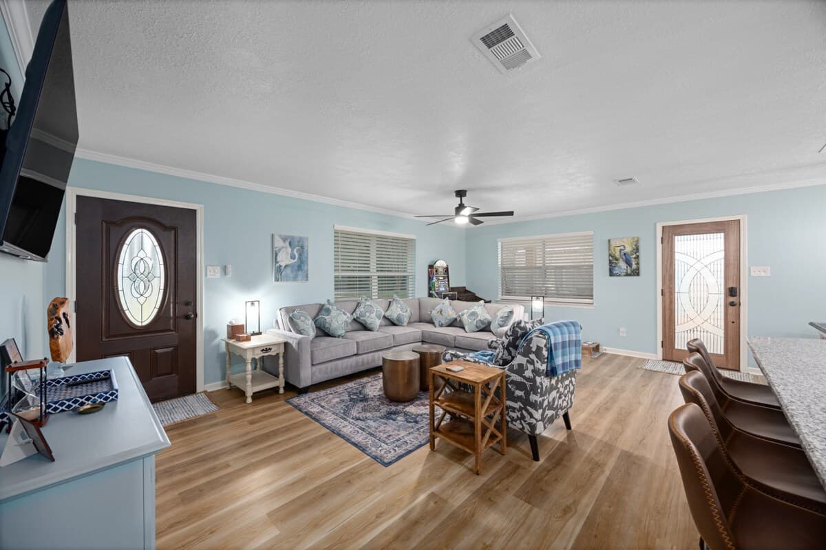 Spacious lounge with plush seating, soft neutral tones, and an easy flow into the kitchen—designed for comfort, conversation, and unwinding together.
