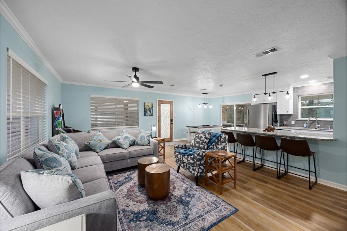 Bright open living space with comfortable seating, tasteful accents, and a modern kitchen bar—ideal for relaxing or gathering after a day outdoors.