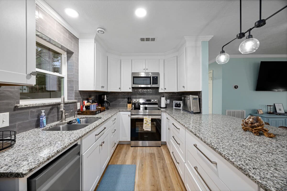 Sleek kitchen with granite counters, stainless appliances, and generous workspace—perfect for cooking, prepping, and serving meals with ease.