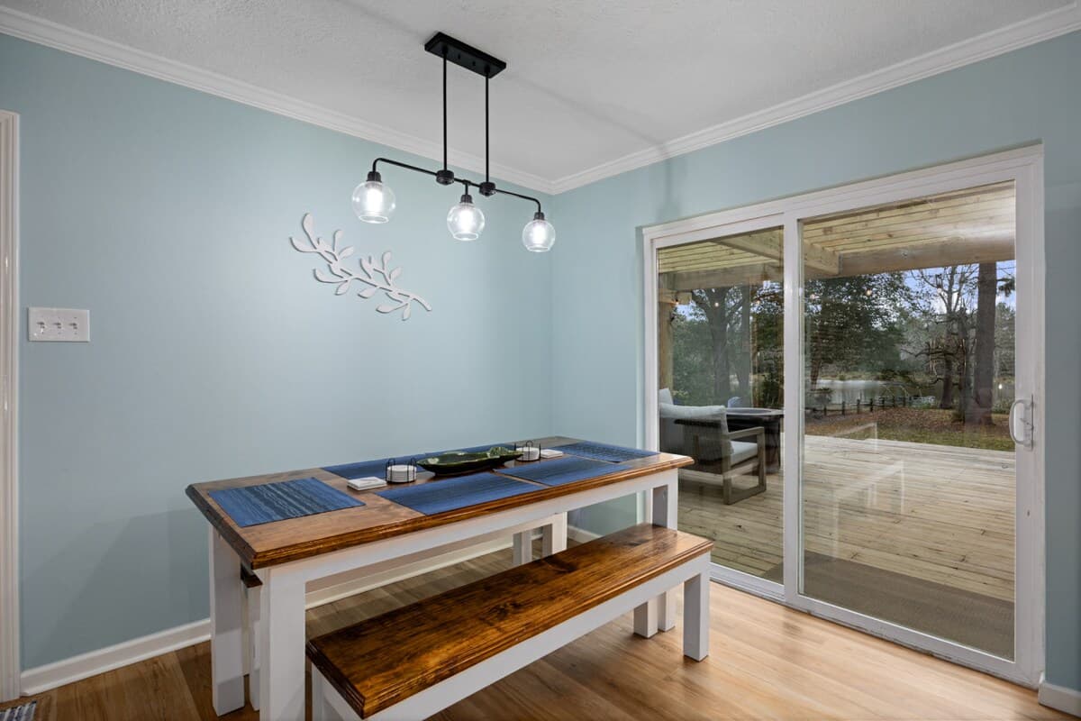 Dining nook with bench seating and pendant lighting, opening to the pergola deck for easy indoor-outdoor meals.
