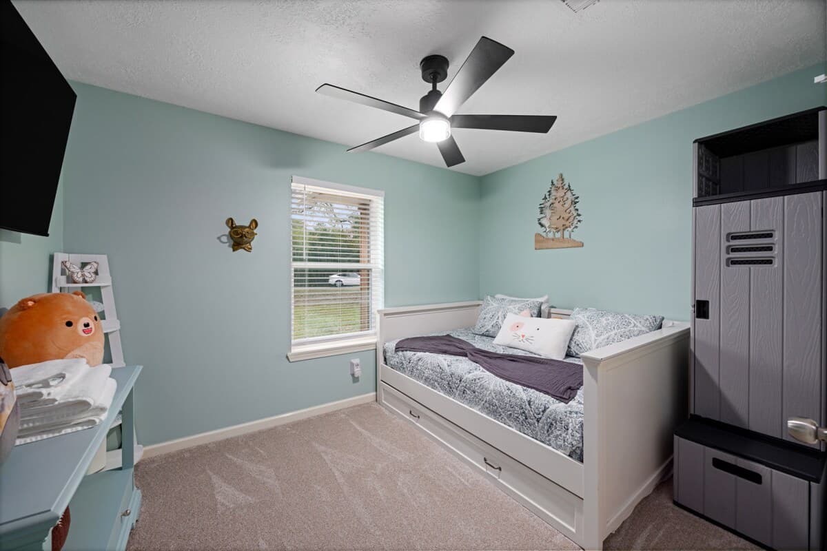 Versatile bedroom featuring a full-size bed with a twin trundle and a 55" TV—perfect for kids, friends, or added sleeping space.