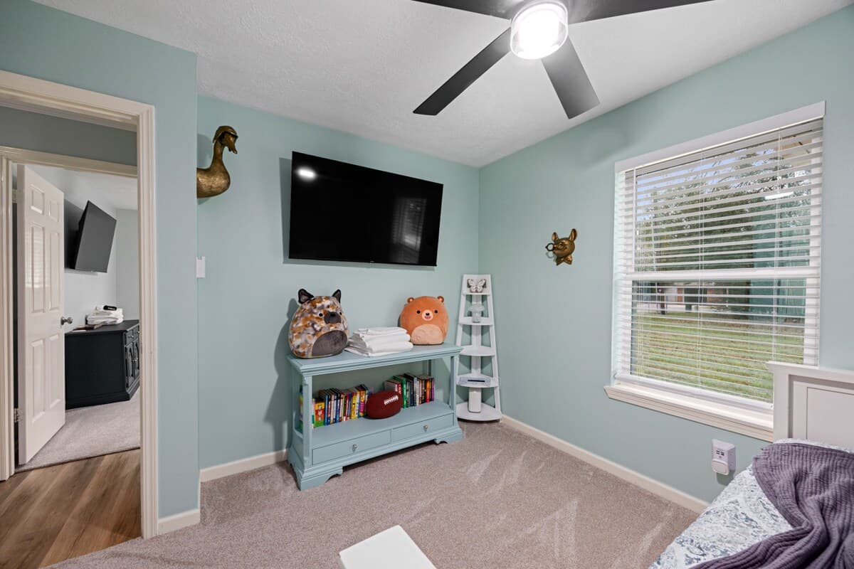 Playful guest room with soft colors, fun décor, and a small library of books for toddlers through adults—perfect for reading and relaxing during your stay at Heron Hollow.