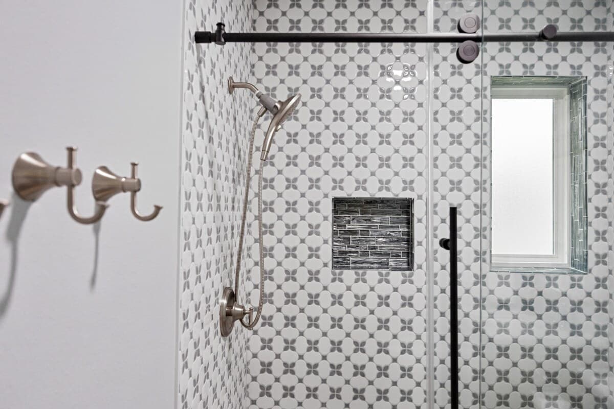 Glass-enclosed shower with custom tile, sliding door hardware, and thoughtful details that elevate the bathroom’s look and feel.