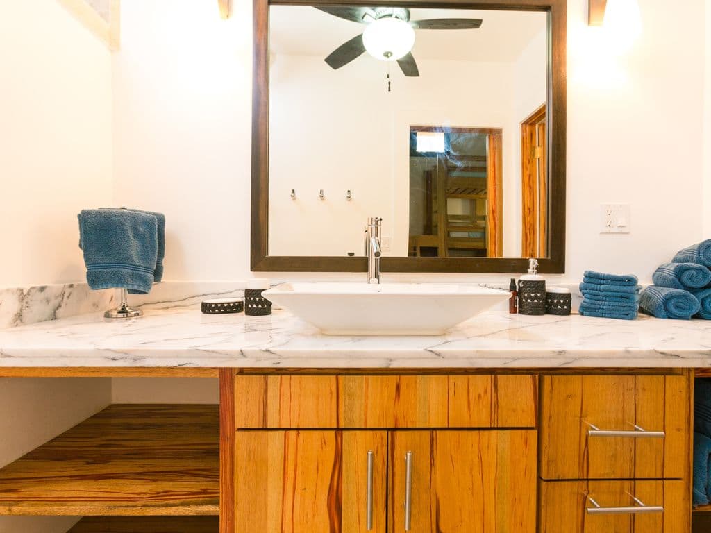 Our bathrooms are spa-like sanctuaries. Bright and airy, they feature natural stone accents and oversized walk-in rainfall showers. The perfect, spacious spot to rinse off the salt and sand after a day in the sun. 🚿✨