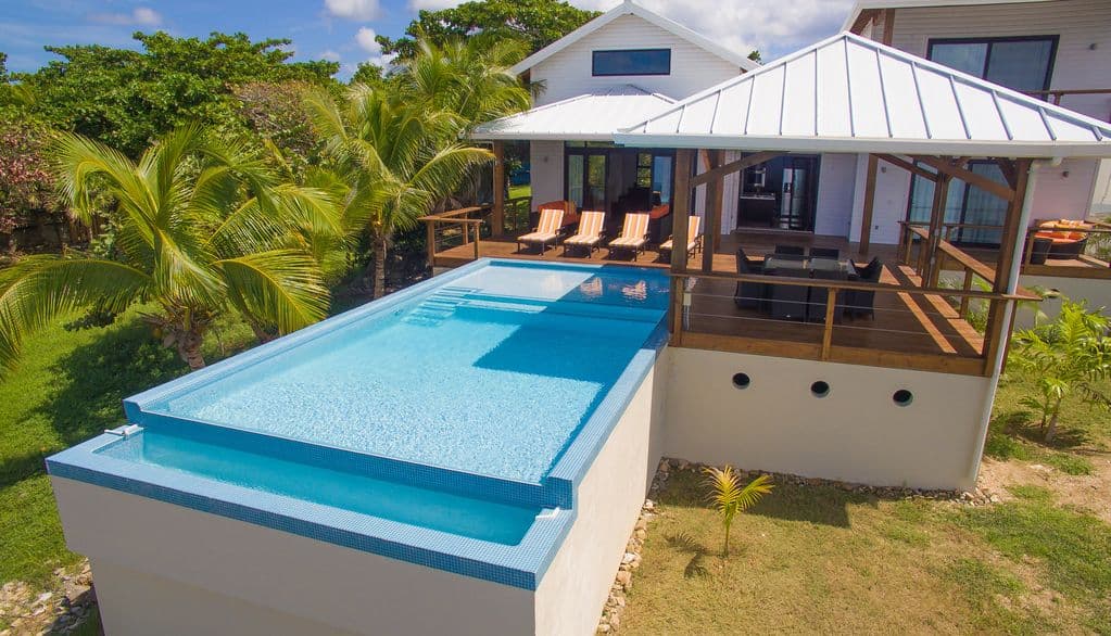 The infinity pool at Vivaro is a masterpiece of "vanishing edge" design, where the water appears to flow directly into the Caribbean Sea 🌊. It serves as the visual centerpiece of the outdoor deck, blending luxury with the natural horizon.