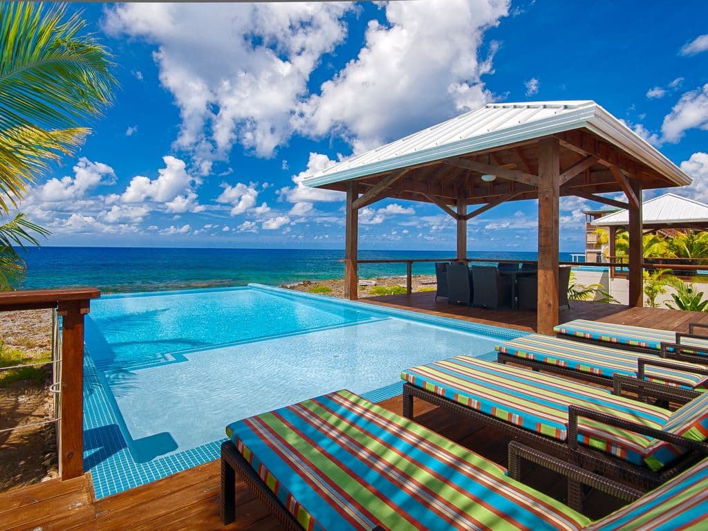 Situated on the iron shore feet from the ocean, the North House deck offers a panoramic "birds-eye" view of the Caribbean. Watch the turquoise reef 🪸 shift into deep indigo as the infinity pool reflects the golden island sunset. Pure tropical immersion.