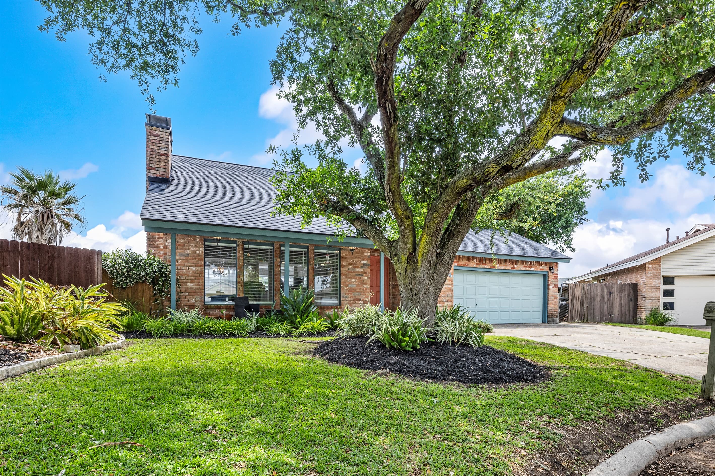 Lakeview Landing set beneath a heritage oak — a landmark Galveston waterfront property on Madeline Lake, sleeps 10.