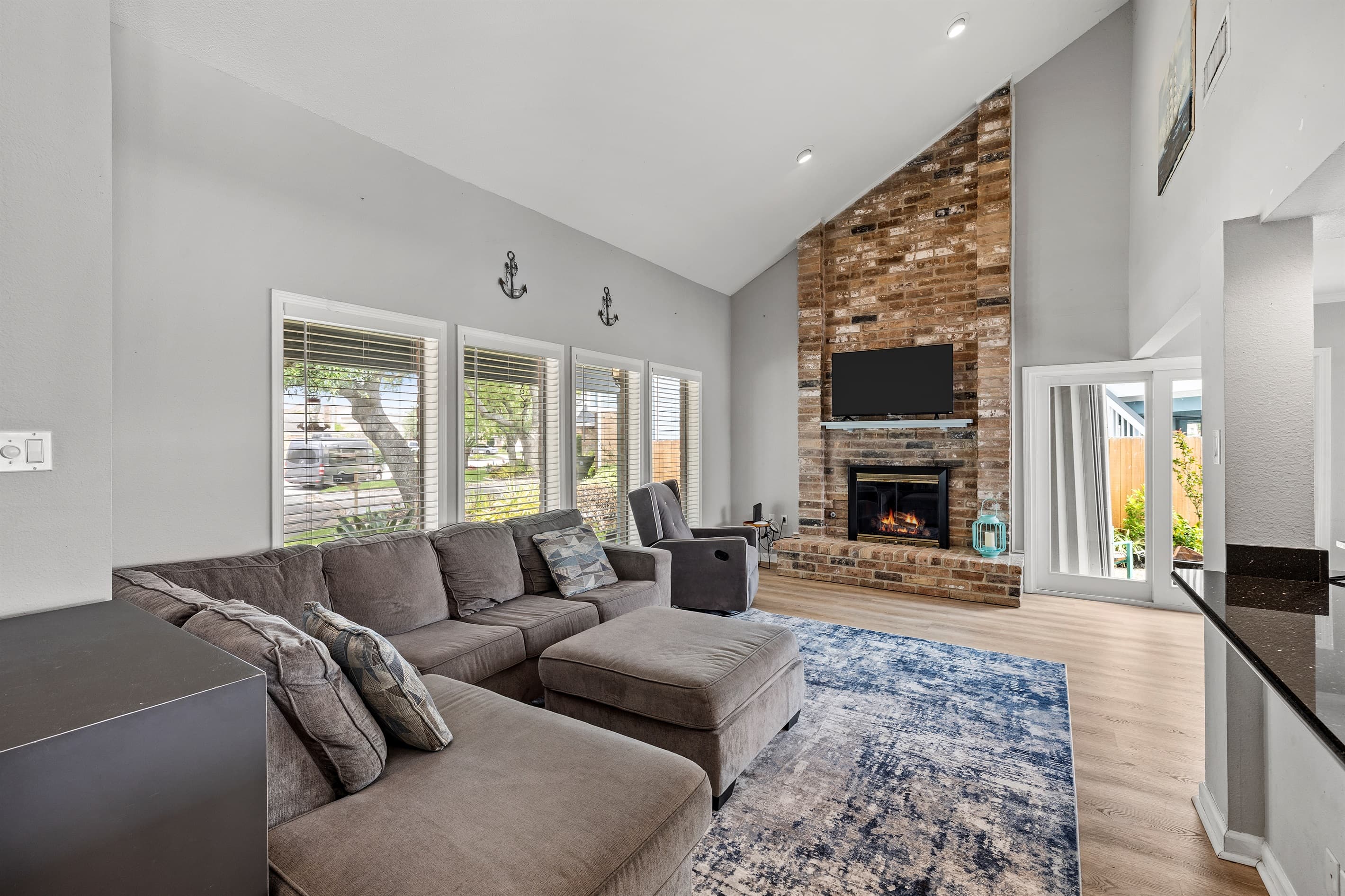 Open-concept living room at Lakeview Landing — vaulted ceilings, stone fireplace, and comfortable seating for the whole group to gather.