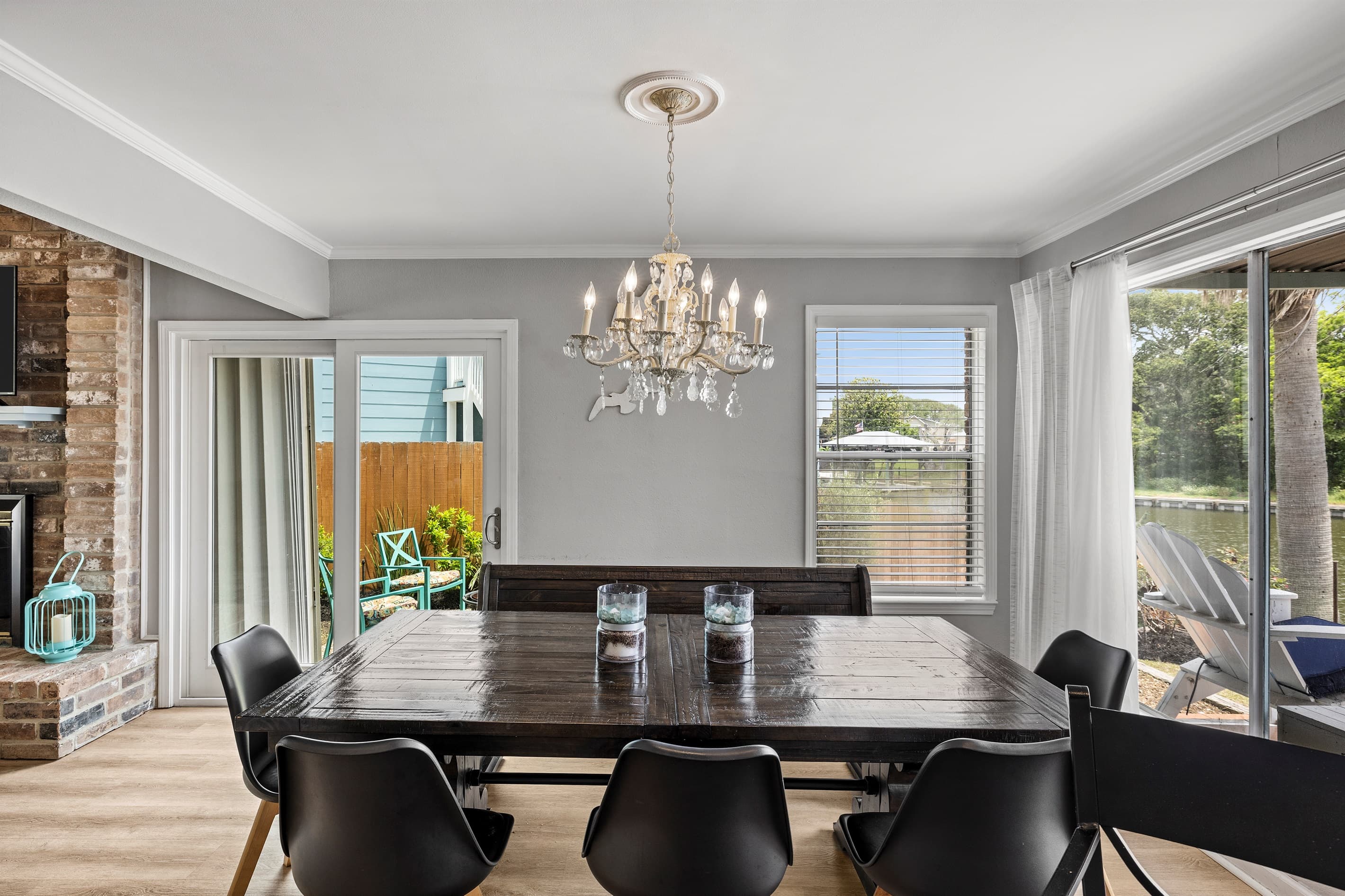 Chandelier-lit dining at Lakeview Landing — gather for meals with natural light and views of the outdoor living space and Galveston sunshine.