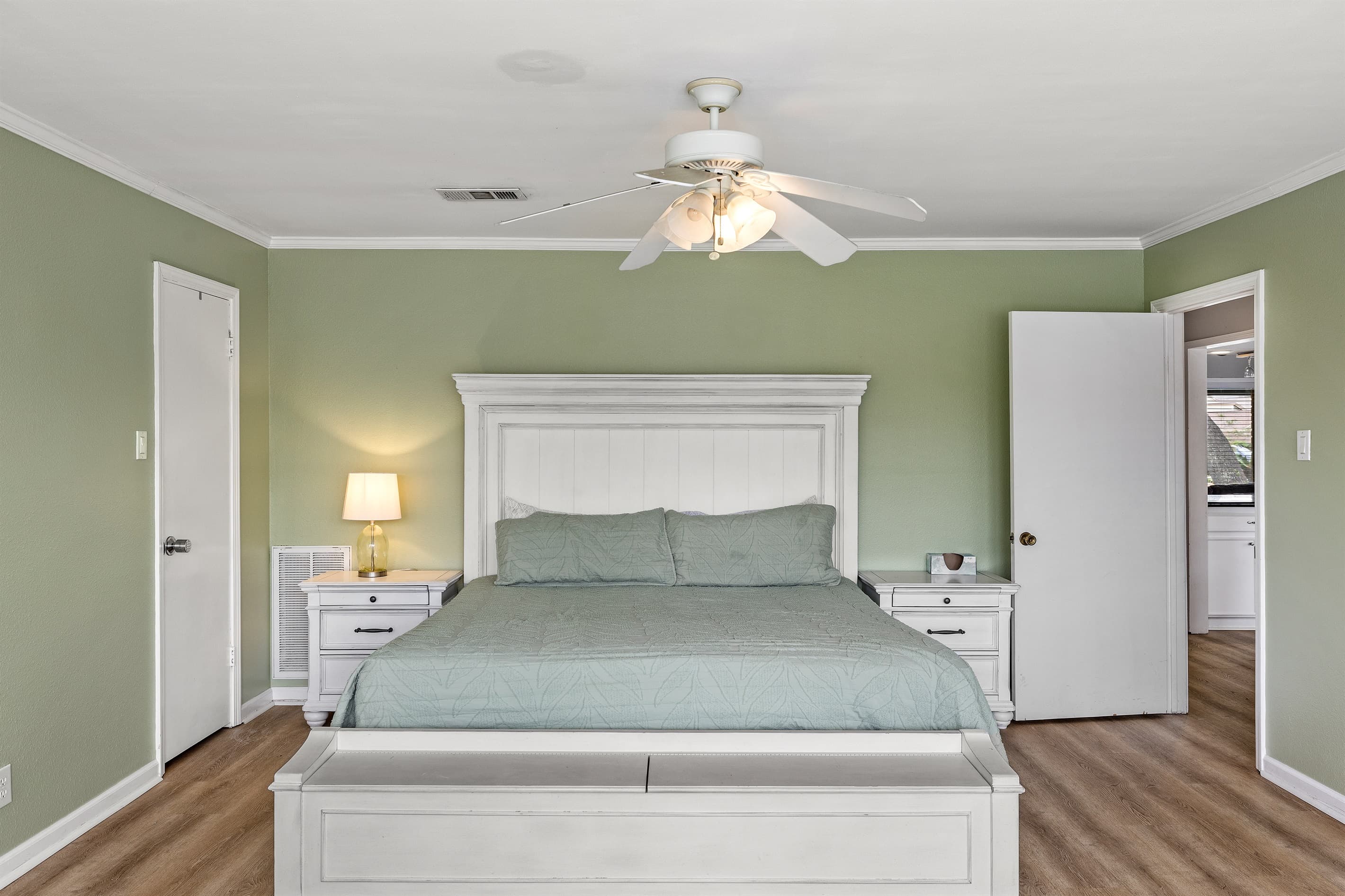Master bedroom at Lakeview Landing — spacious and beautifully appointed with sage green accents and premium bedding for a restful night's sleep.