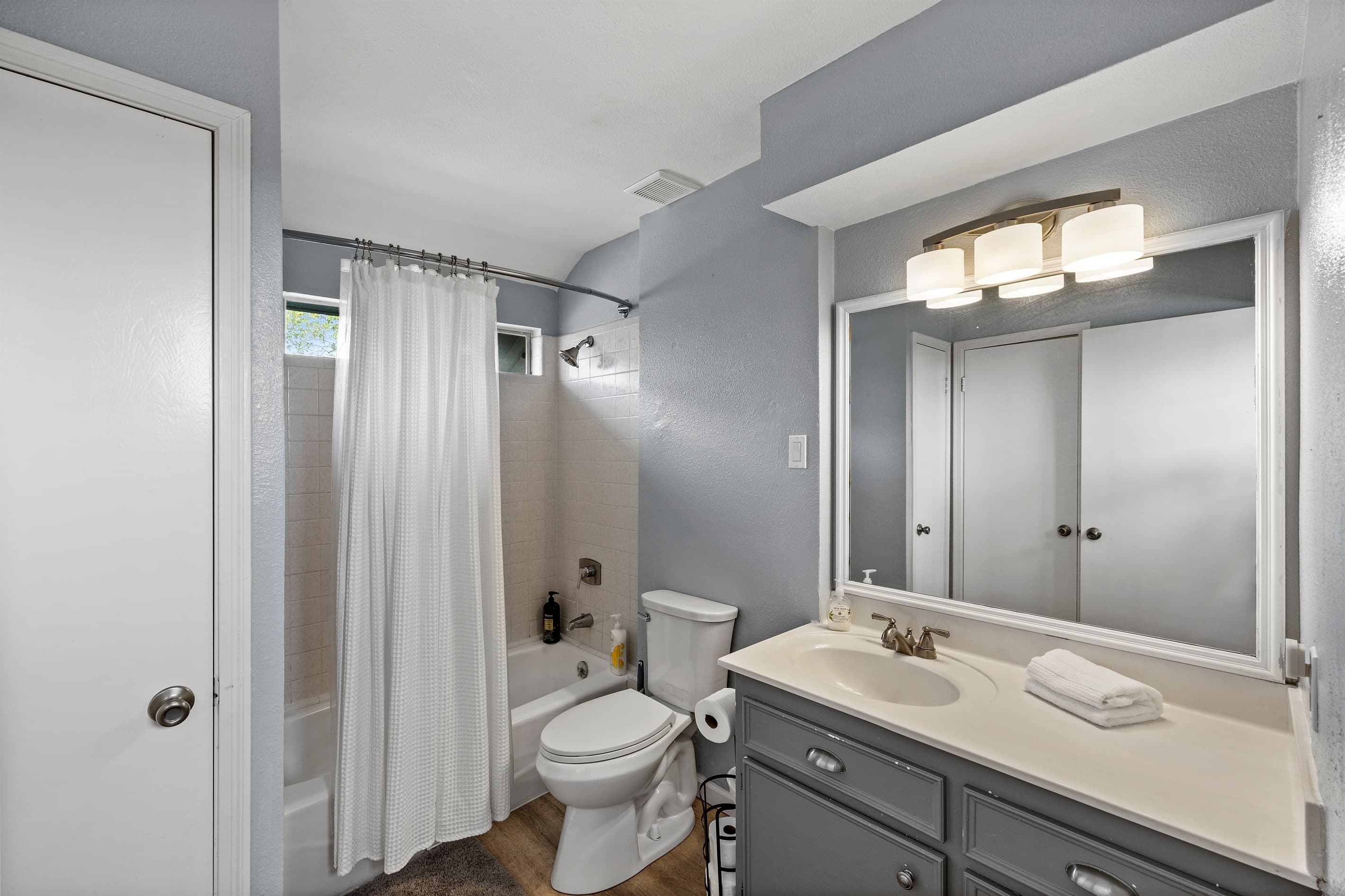 Upstairs full bathroom at Lakeview Landing — updated gray vanity, good lighting, and everything upstairs guests need throughout their stay.