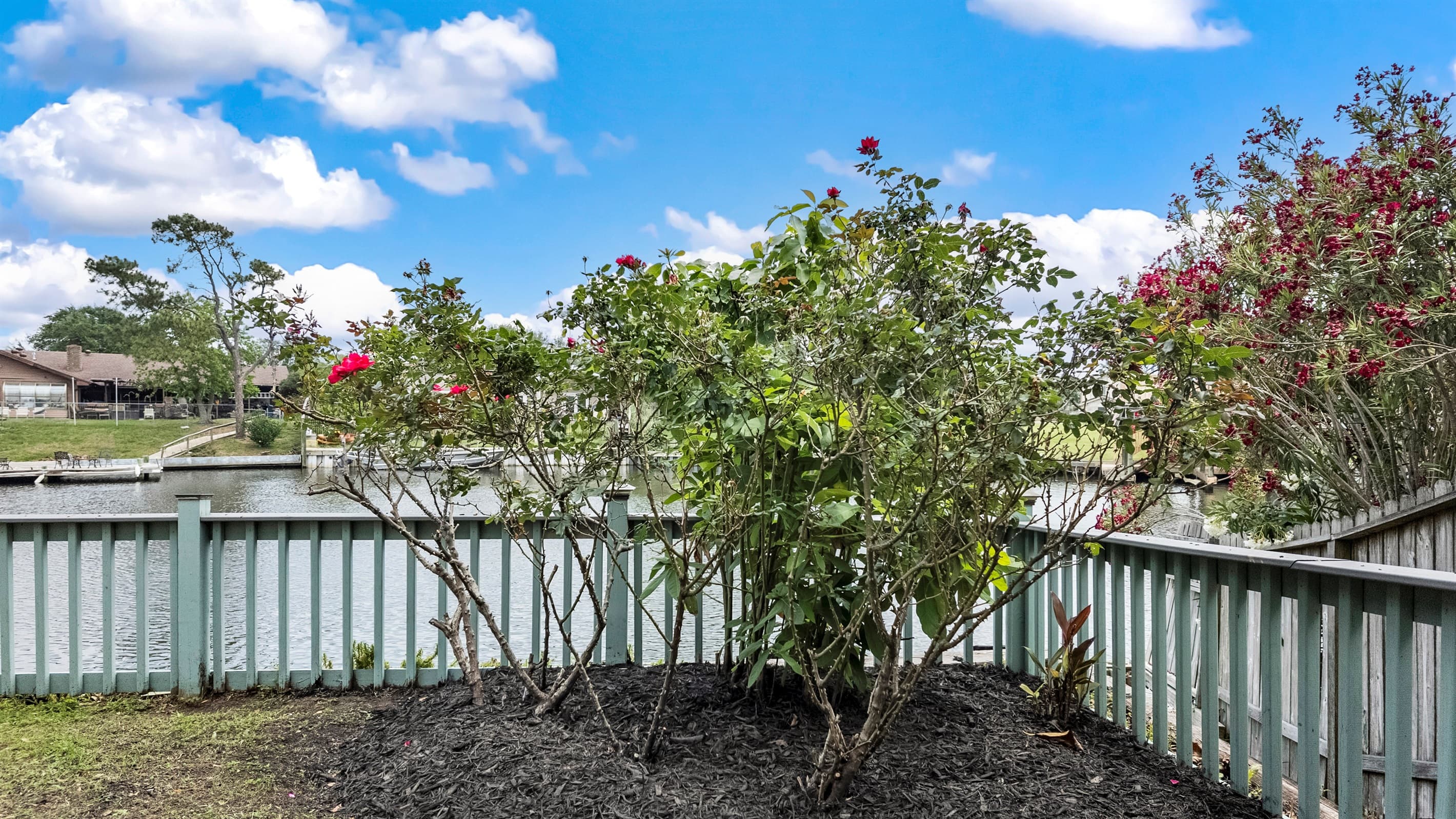 Bougainvillea blooms along the deck railing at Lakeview Landing — natural color and Galveston sunshine frame every outdoor moment.