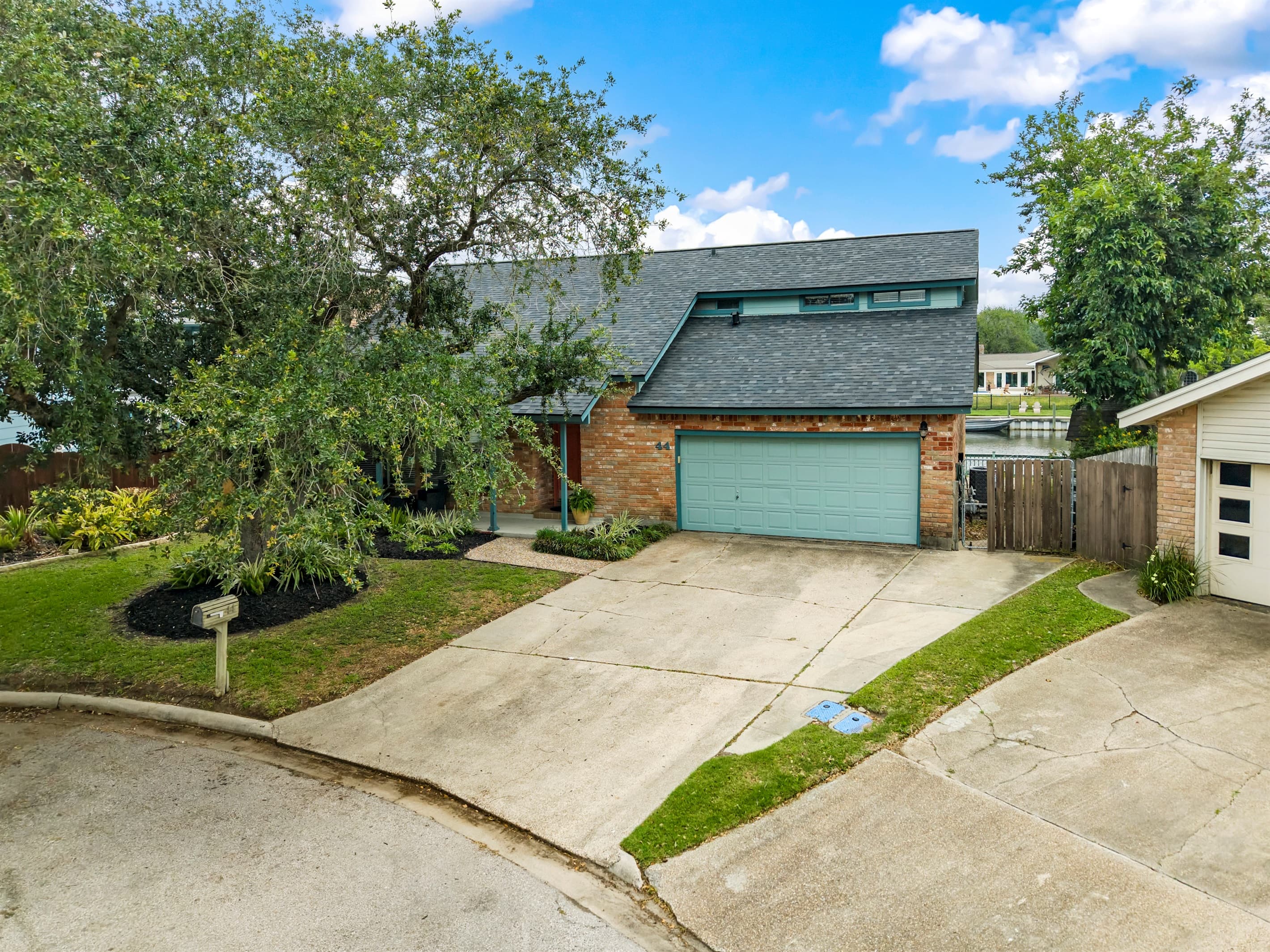 Lakeview Landing front exterior — beautifully maintained home with teal accents at 44 Lakeview Drive, Galveston TX.