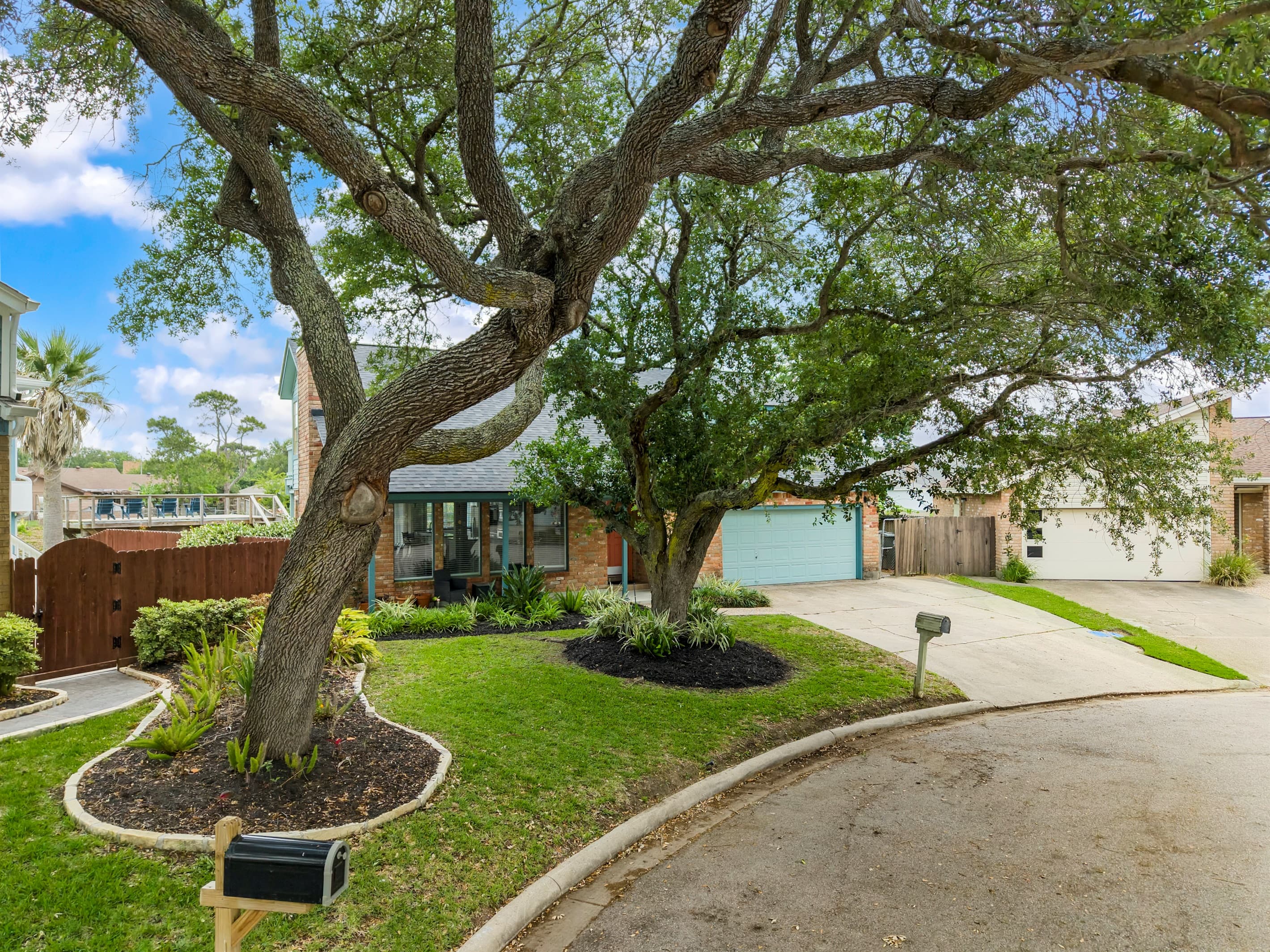 Lakeview Landing beneath a heritage oak — classic Galveston curb appeal with lush mature landscaping at 44 Lakeview Drive.
