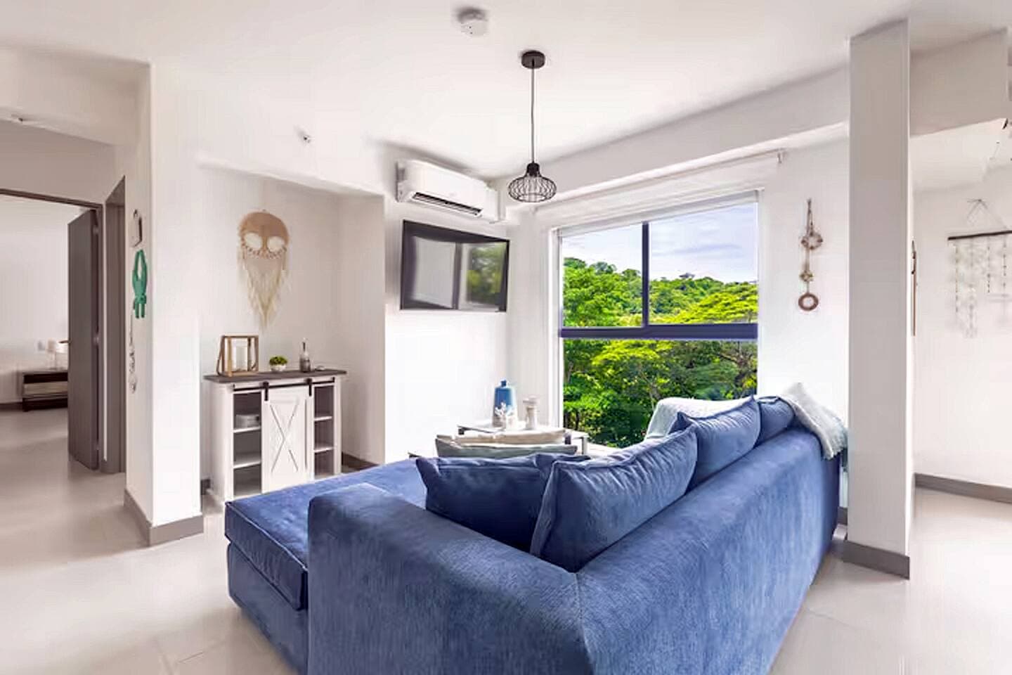 Our living room is a beautifully lit, open space. This apartment was originally designed with 3 bedrooms, but we opened the third to expand the living area, creating a more spacious and inviting ambiance.