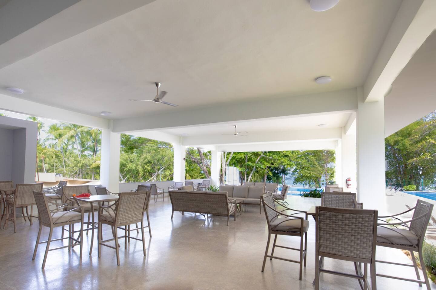 Under-roof social area at the Beach Club, offering shade, comfort, and space to relax.