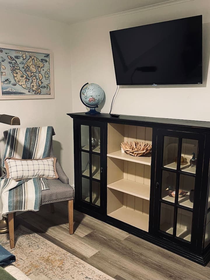 A cozy corner invites quiet moments with a comfortable chair and soft light, while carefully arranged details add charm and character to the room.