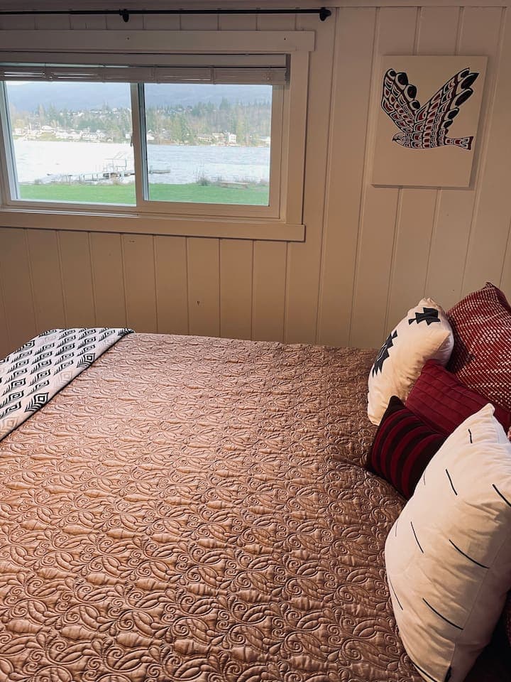 From the master bedroom, the window frames a serene view of the lake, bringing natural calm and a peaceful connection to the outdoors into the room.