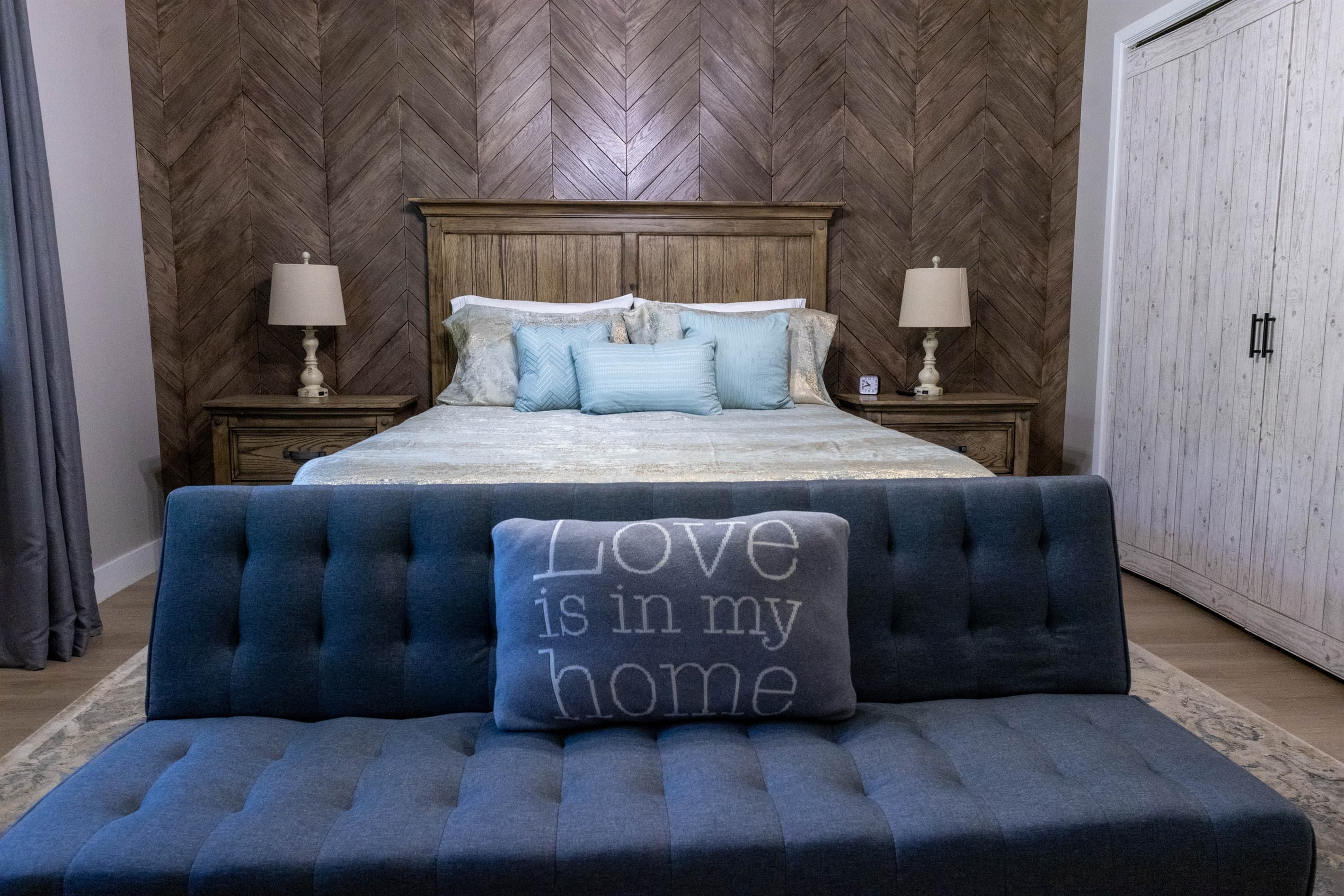 Your comfortable escape: primary bedroom with TV, pull-down couch, desk, soft carpet, dresser, closet, USB lamps, and cozy robes.