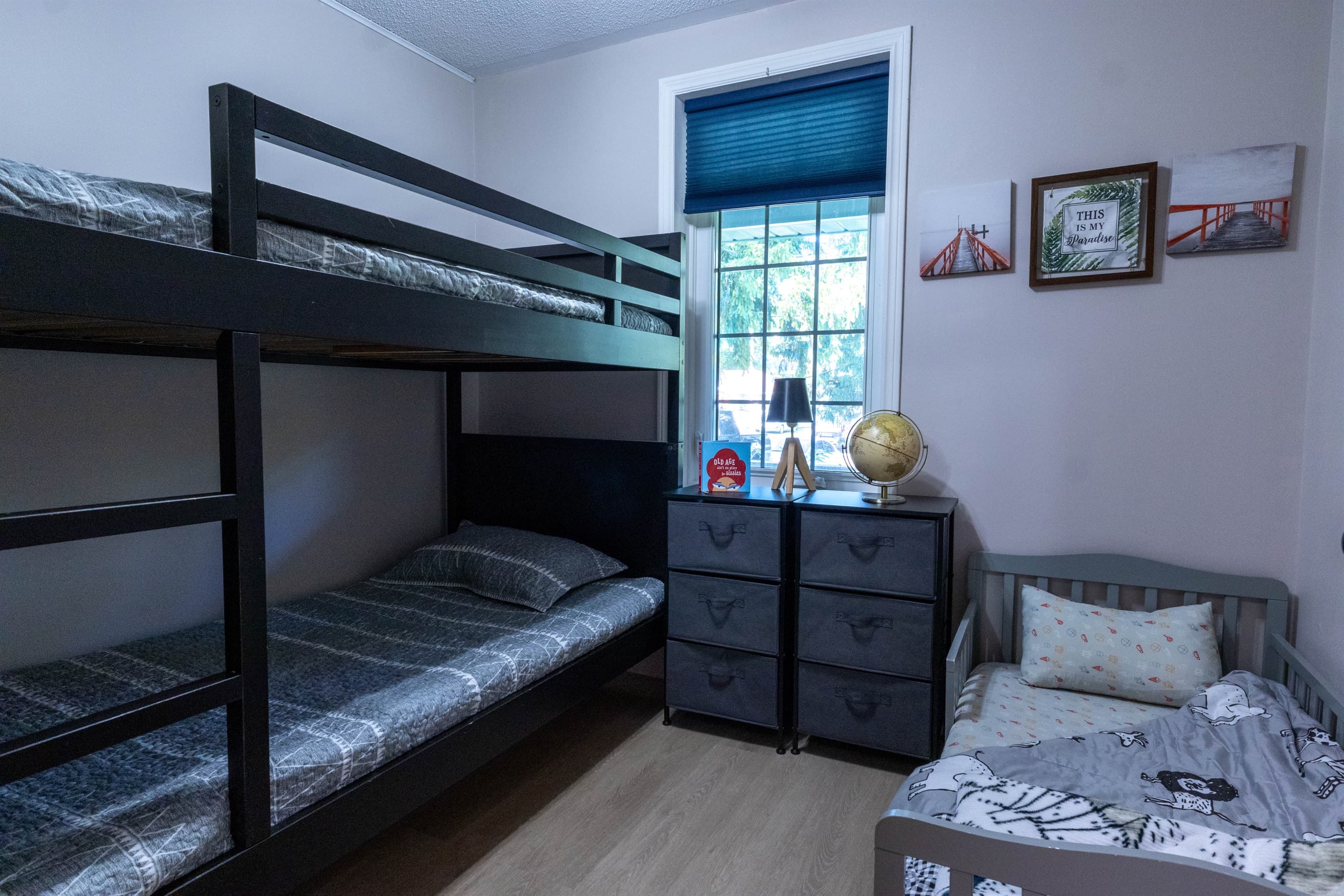 Family-friendly third bedroom featuring a twin bunk and toddler bed, suitable for both kids and adults.