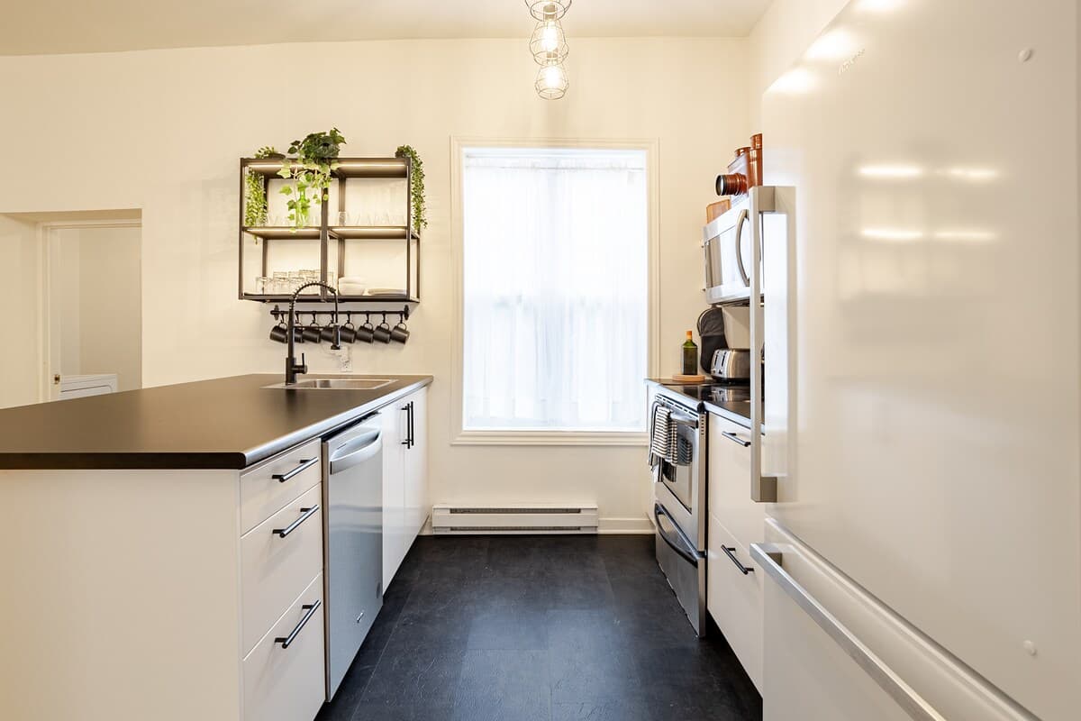 Fully equipped kitchen with modern appliances, spices, quality knives, cookware, and dishwasher. Ideal for cooking, coffee, or casual dining in a sleek, organized space that opens to the dining area—perfect for foodies and families alike.