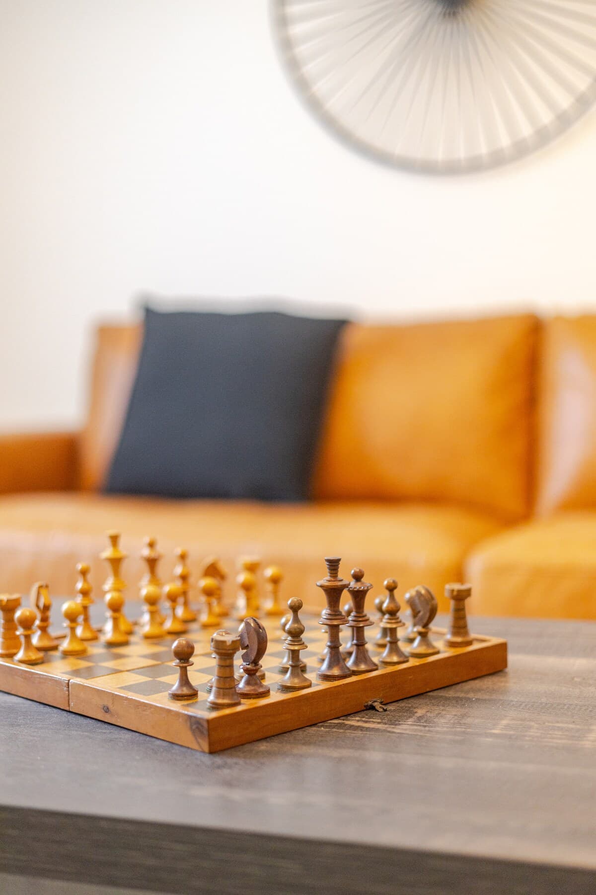 Bright and stylish living room with mid-century charm, leather sofa, smart TV, chic decor, and a cozy vibe—perfect for relaxing, working remotely, or enjoying a game night. Air-conditioned and filled with natural light for year-round comfort.