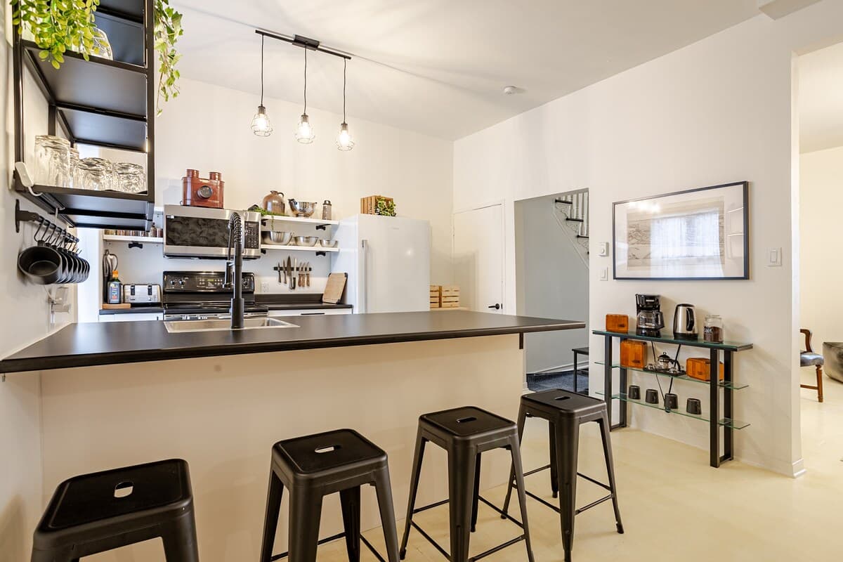 Fully equipped kitchen with modern appliances, spices, quality knives, cookware, and dishwasher. Ideal for cooking, coffee, or casual dining in a sleek, organized space that opens to the dining area—perfect for foodies and families alike.