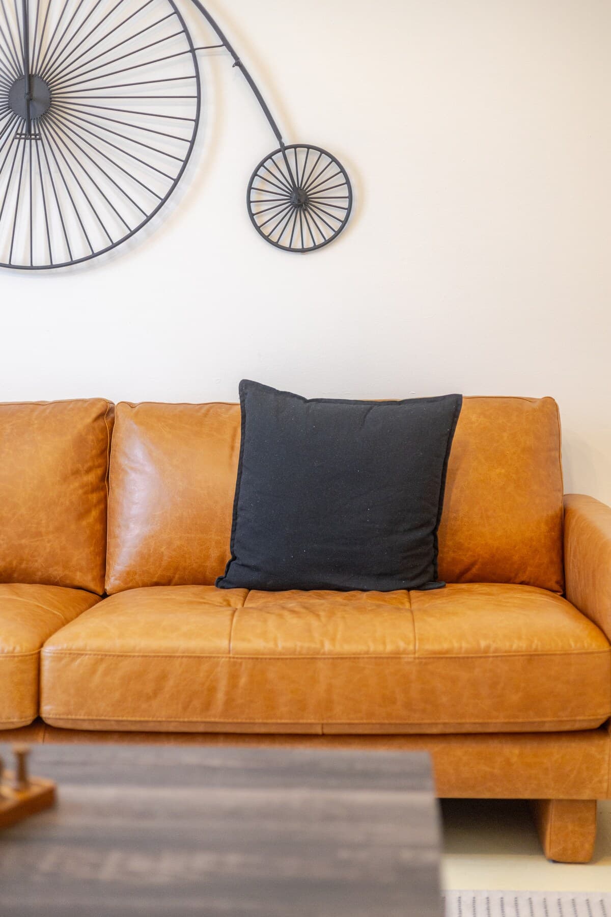 Bright and stylish living room with mid-century charm, leather sofa, smart TV, chic decor, and a cozy vibe—perfect for relaxing, working remotely, or enjoying a game night. Air-conditioned and filled with natural light for year-round comfort.