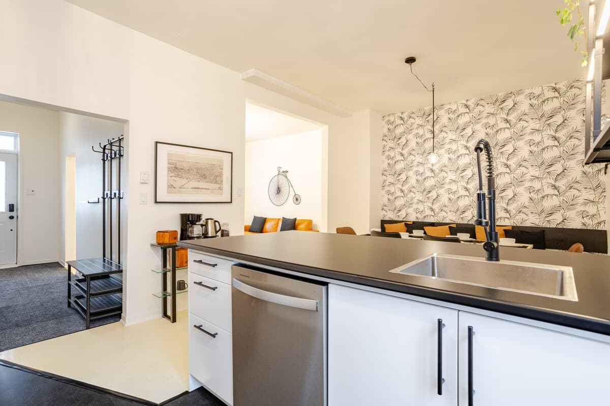 Fully equipped kitchen with modern appliances, spices, quality knives, cookware, and dishwasher. Ideal for cooking, coffee, or casual dining in a sleek, organized space that opens to the dining area—perfect for foodies and families alike.