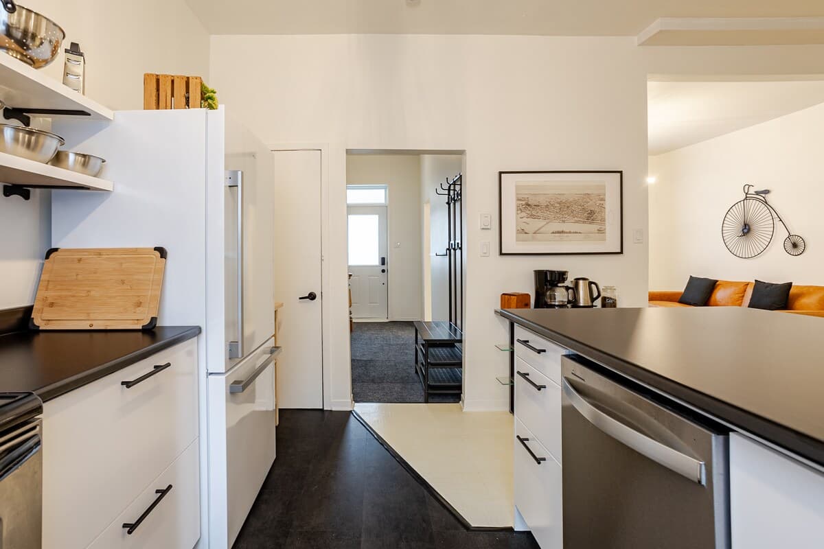 Fully equipped kitchen with modern appliances, spices, quality knives, cookware, and dishwasher. Ideal for cooking, coffee, or casual dining in a sleek, organized space that opens to the dining area—perfect for foodies and families alike.