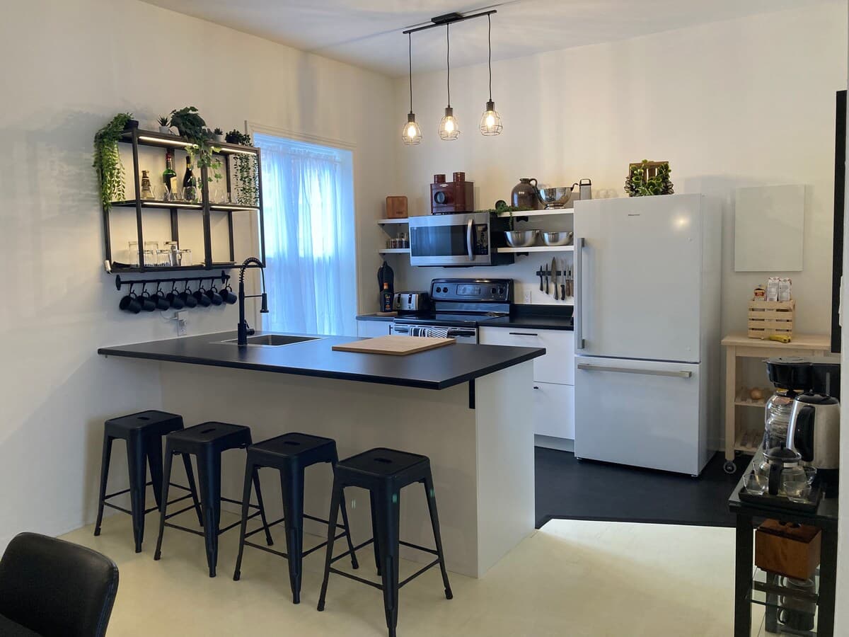 Fully equipped kitchen with modern appliances, spices, quality knives, cookware, and dishwasher. Ideal for cooking, coffee, or casual dining in a sleek, organized space that opens to the dining area—perfect for foodies and families alike.