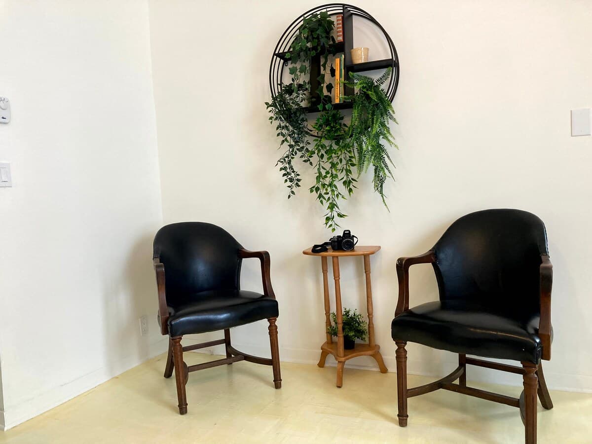 Bright and stylish living room with mid-century charm, leather sofa, smart TV, chic decor, and a cozy vibe—perfect for relaxing, working remotely, or enjoying a game night. Air-conditioned and filled with natural light for year-round comfort.