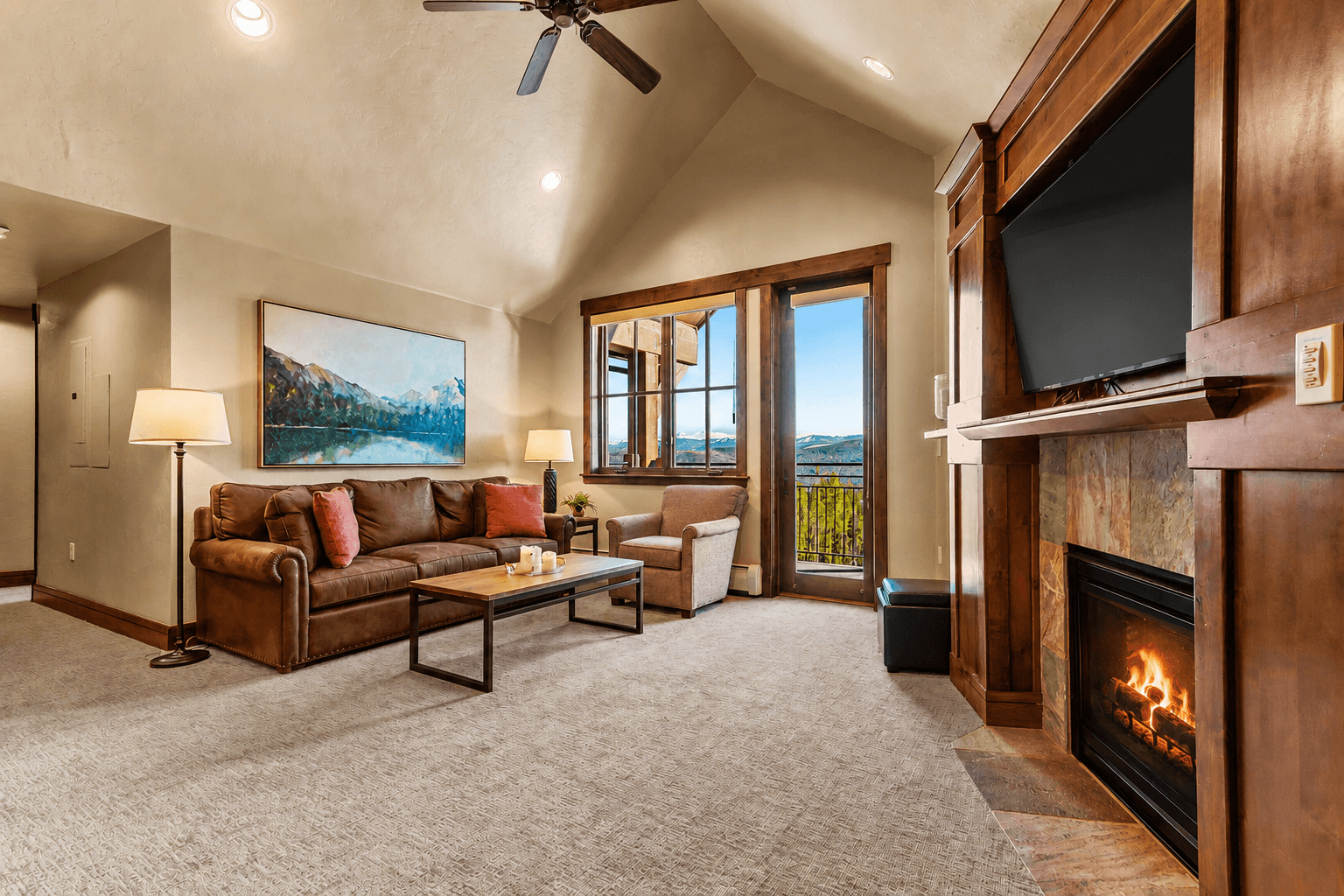 Bright living room with private balcony & fireplace.