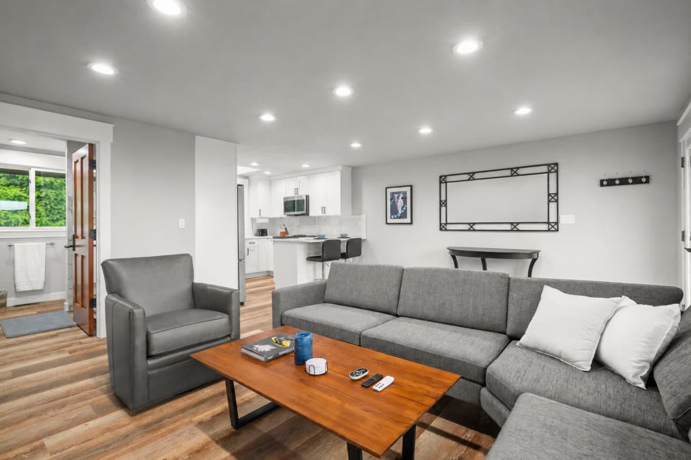 Bright open-concept living room with abundant natural light and a spacious sectional sofa, perfect for relaxing and comfortably watching sports and entertainment..png