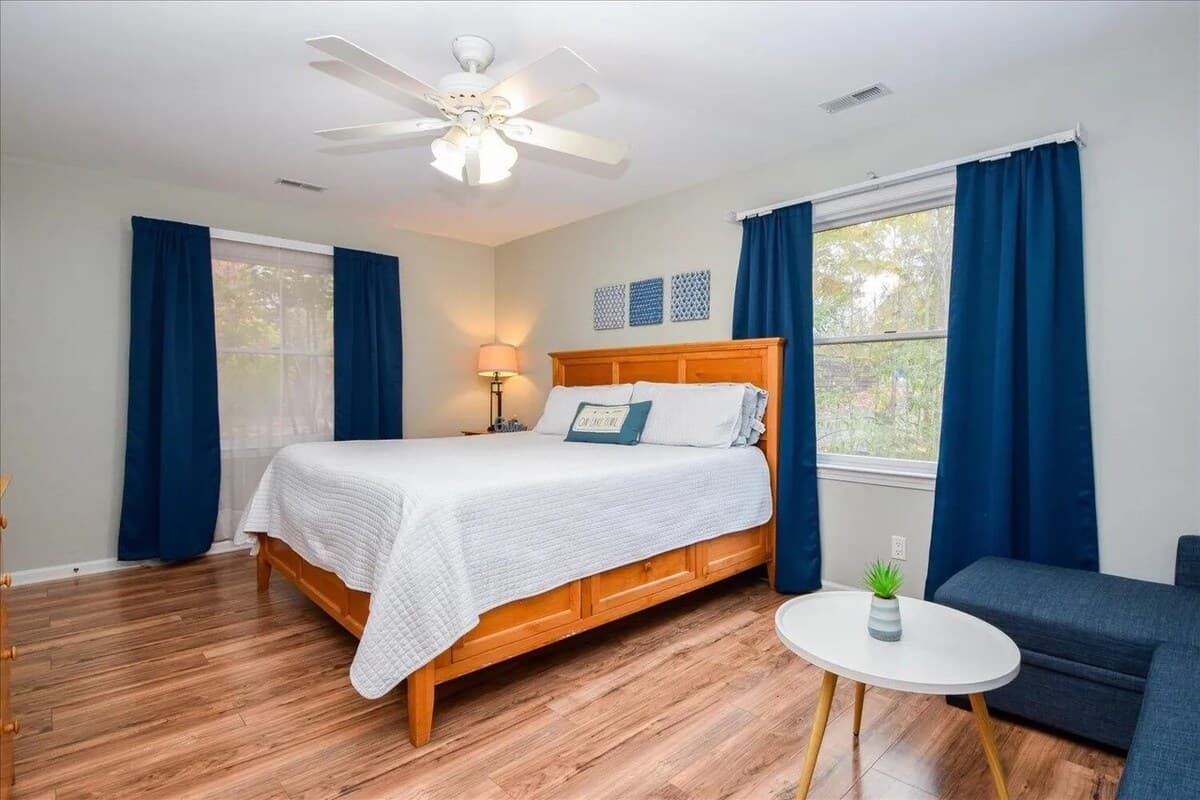 Light Wood King bedroom, sleeper sofa, chaise sectional, natural light, Navy room darkening curtains, coastal modern, family-friendly, sleeps 3+.