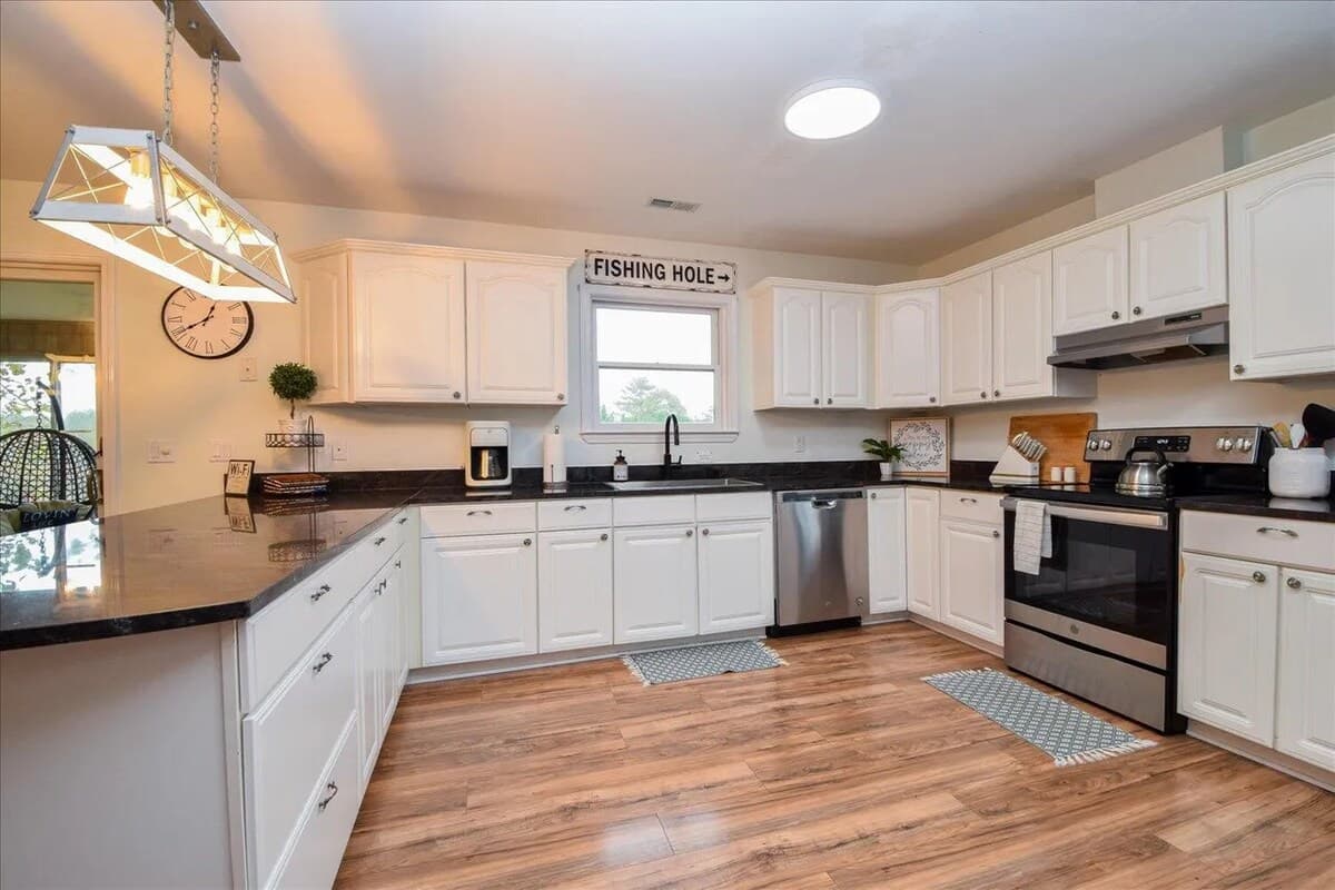  Bright, fully equipped kitchen — dishwasher, range, and everything in between. Stainless dishwasher, electric range, granite sink, coffee maker, bright kitchen, white cabinetry, fully equipped, lake house kitchen.