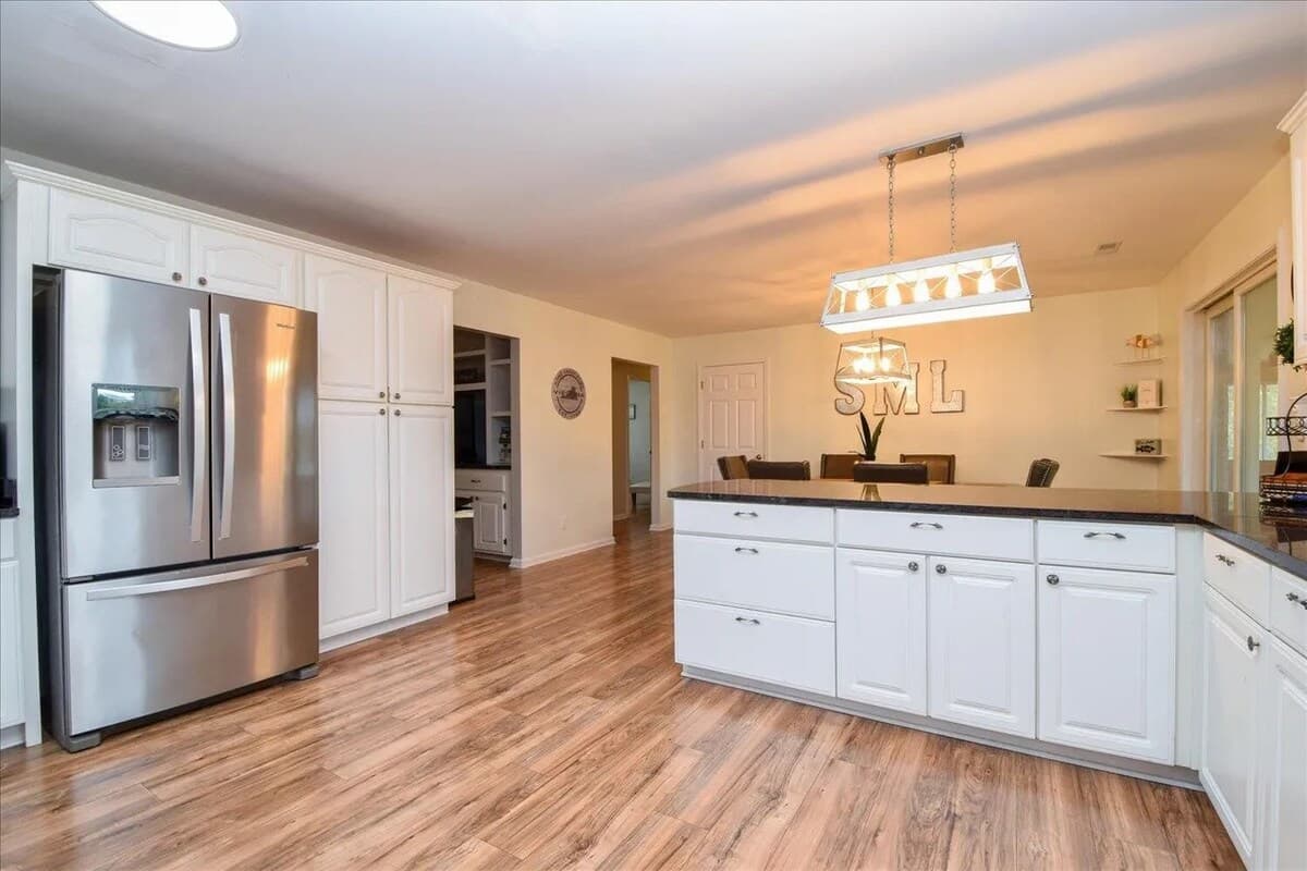 Full chef's kitchen — stainless appliances and counter space for big group meals. tainless appliances, French-door fridge, ice maker, electric range, microwave, granite counters, full kitchen, chef's kitchen, large group cooking.
