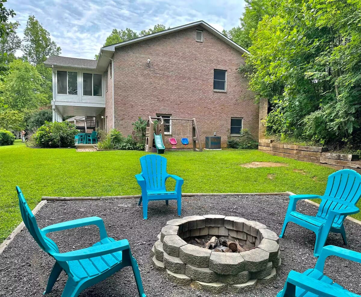 Backyard fire pit ringed by 4 teal Adirondack chairs — lake-house nights.

fire pit, Adirondack chairs, backyard fire pit, firewood provided, outdoor gathering, kid-friendly yard, playground visible, Smith Mountain Lake.
