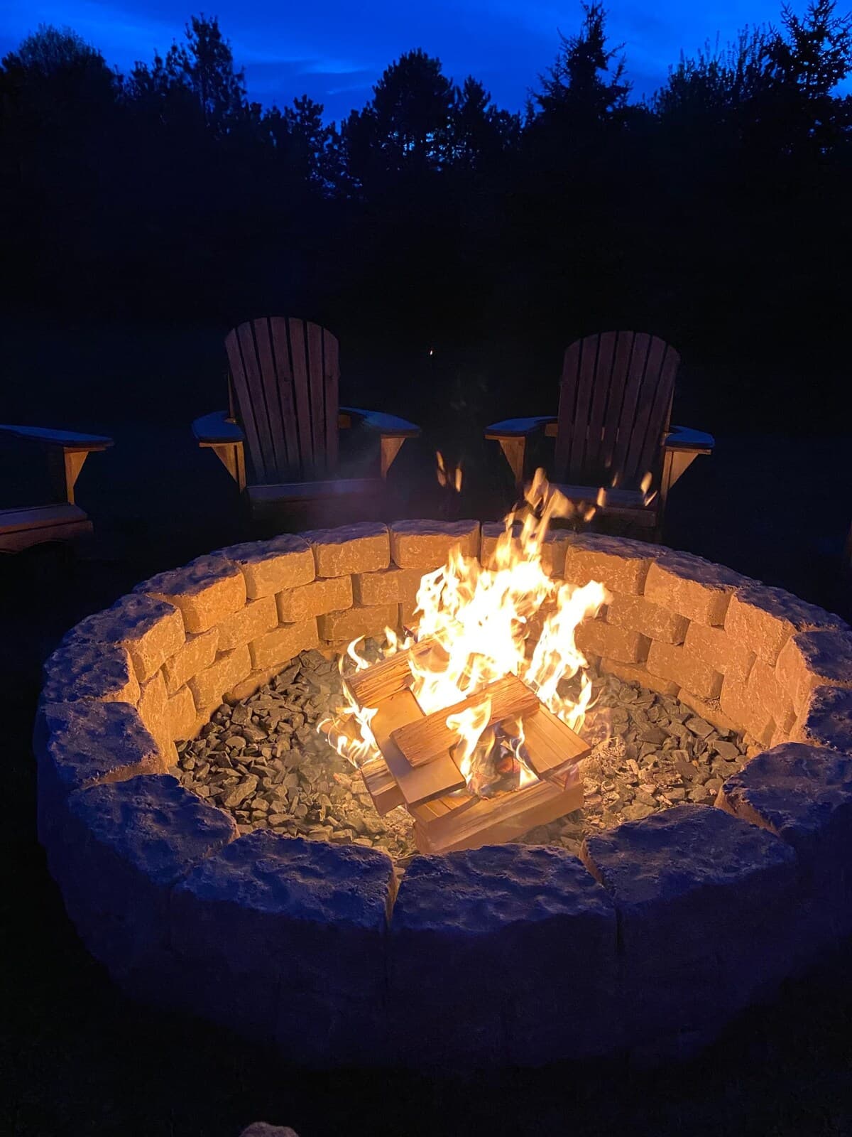 Stone fire pit ablaze at night — lakehouse s'mores under the stars.

Fire pit at night, s'mores, Adirondack chairs, outdoor entertaining, evening lake views, stargazing, romantic getaway, Smith Mountain Lake nights.