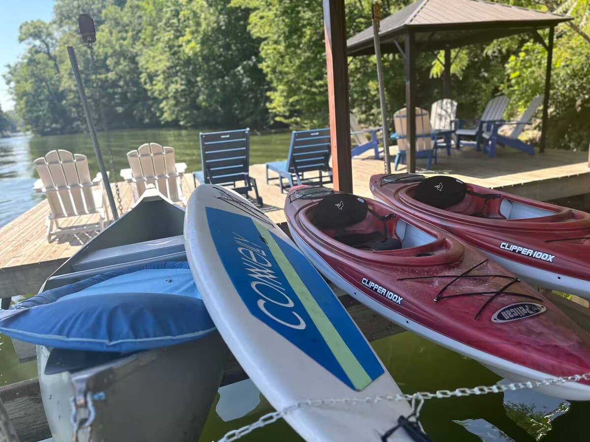 Full watercraft lineup — kayaks, paddleboard, pedal boat all at the dock.