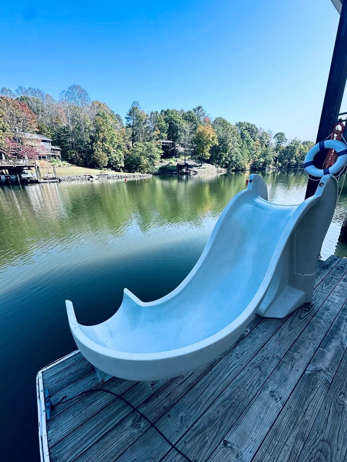 Dock water slide — splash straight into deep, crystal-clear cove water.

ke slide, dock slide, water slide, deep crystal-clear water, swimming, family-friendly, kid-friendly, unique lake amenity, Smith Mountain Lake.