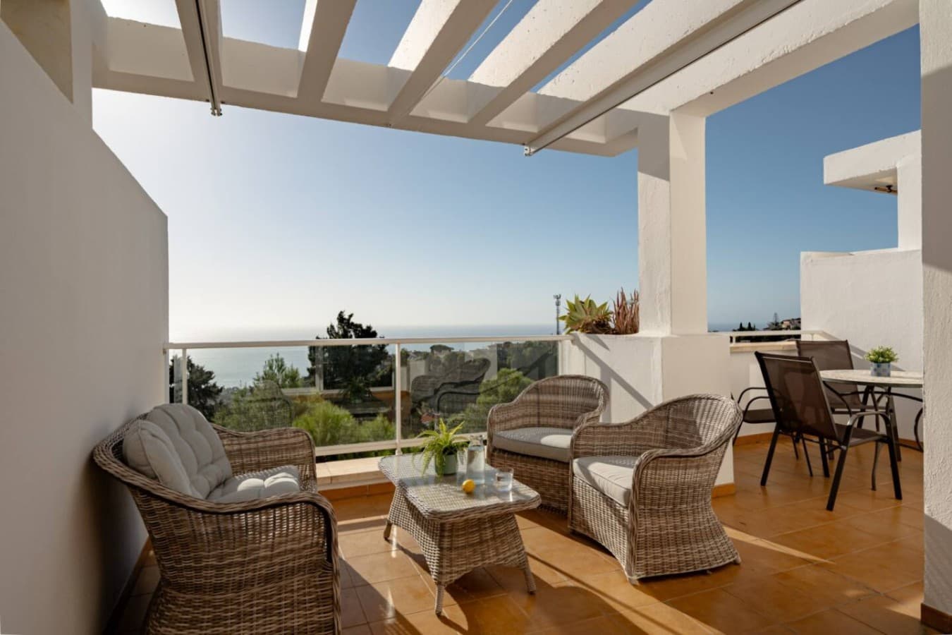 Step out onto the expansive terrace and let the vacation truly begin. Relax in the comfortable wicker seating area, shielded by the stylish pergola, and soak in the breathtaking Mediterranean view.